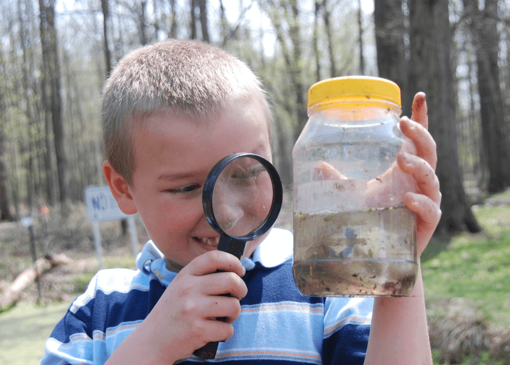 boy looking through magnifying glass
