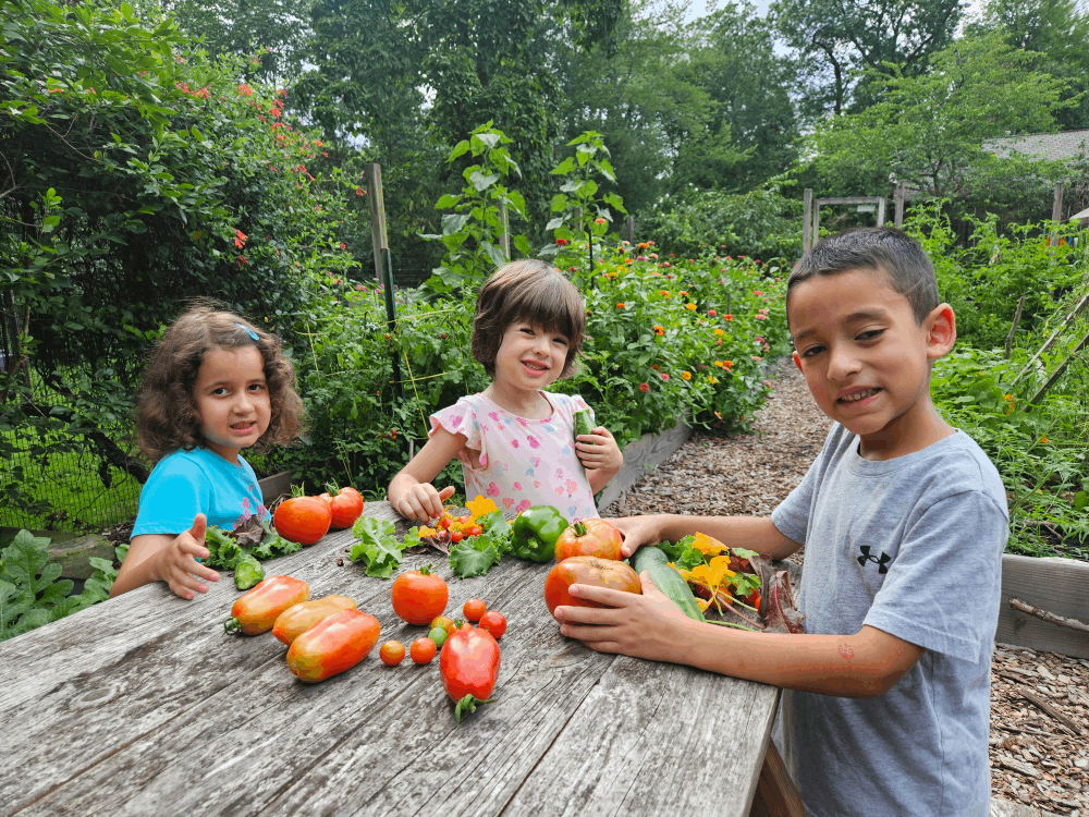 kids gathered around a table with produce