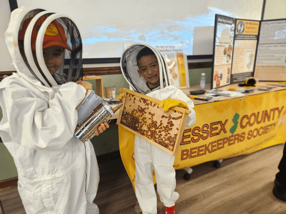 two kids in beekeeper suits